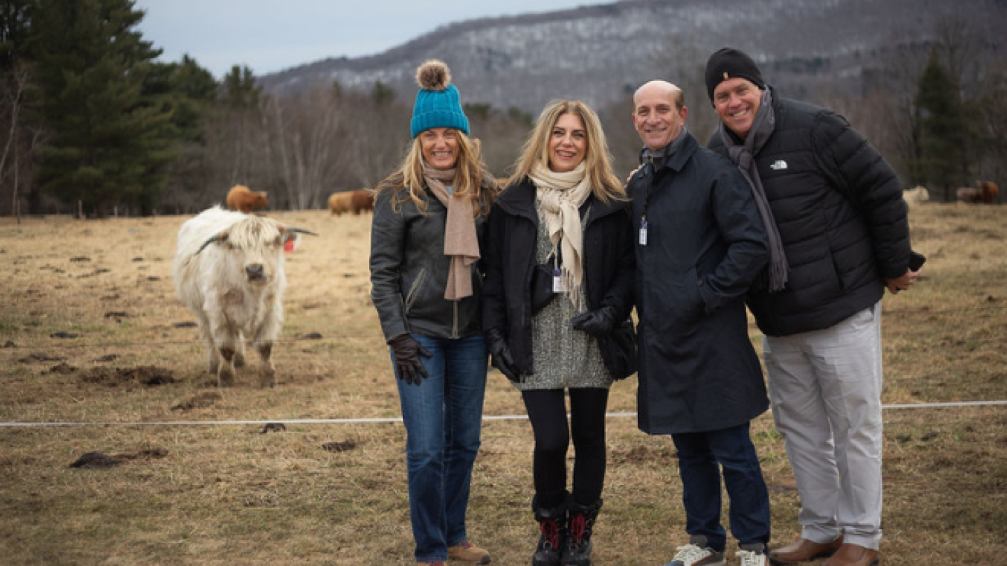 Four people post next to a highland cow in Stowe, Vermont